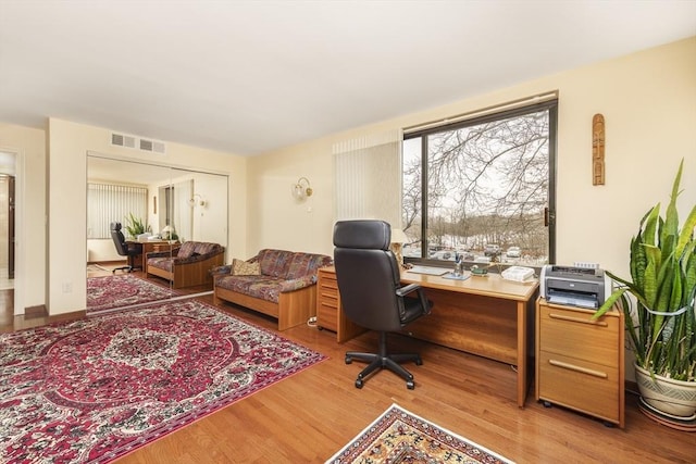 home office with visible vents and wood finished floors