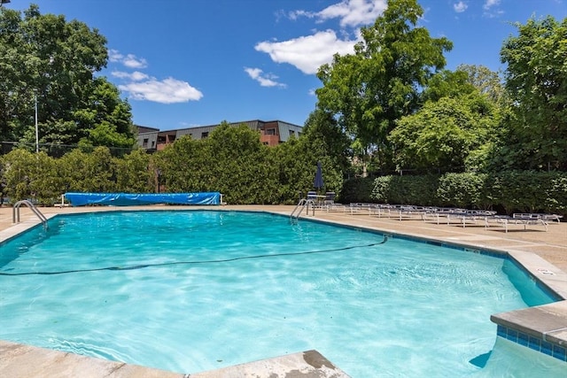 community pool with a patio and fence