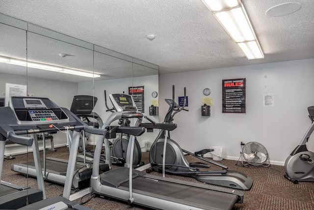 exercise room featuring baseboards and a textured ceiling