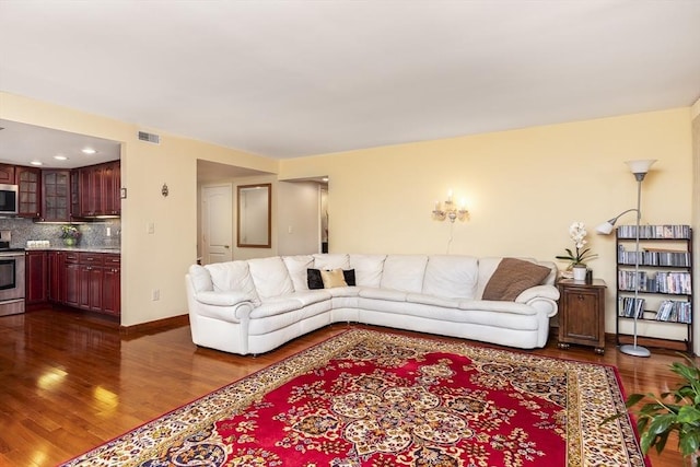 living room with visible vents, dark wood finished floors, and baseboards