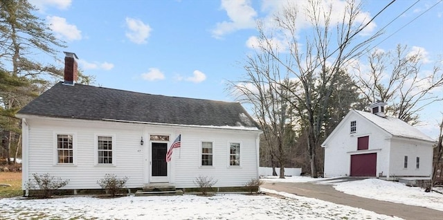 view of front of house featuring a garage and an outbuilding