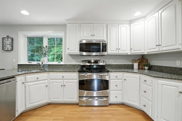 56 R F Higgins Dr, Norwell, MA 02061 - kitchen featuring appliances with stainless steel finishes, white cabinetry, recessed lighting, dark stone countertops, and light wood finished floors