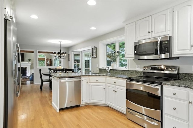 56 R F Higgins Dr, Norwell, MA 02061 - kitchen with appliances with stainless steel finishes, light wood finished floors, white cabinets, and recessed lighting