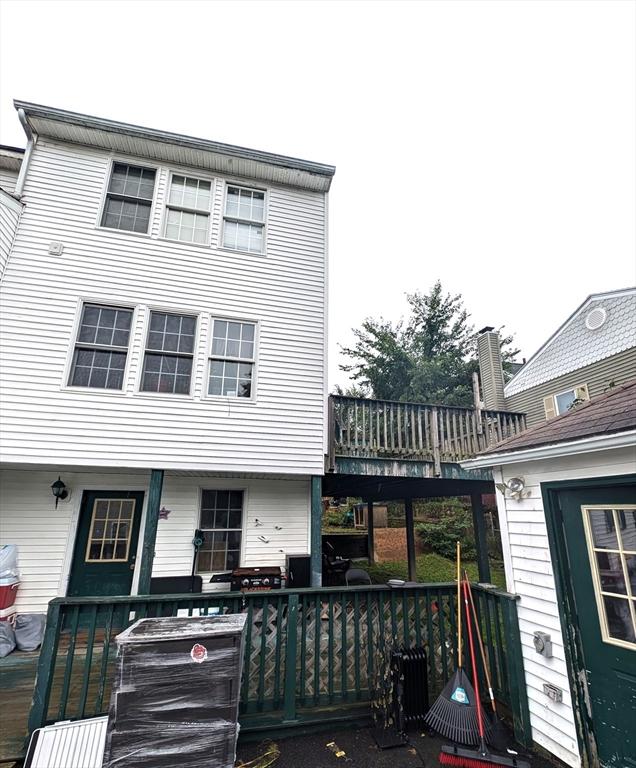 back of property featuring a wooden deck