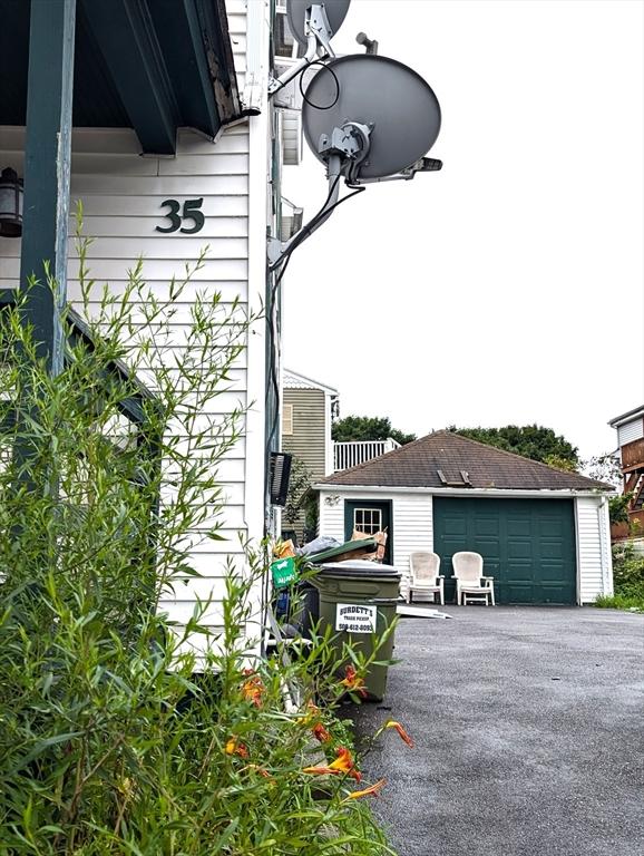 view of property exterior featuring a detached garage and an outdoor structure