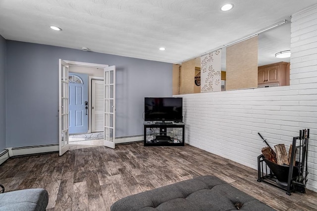 living area featuring a baseboard heating unit, wood finished floors, and recessed lighting