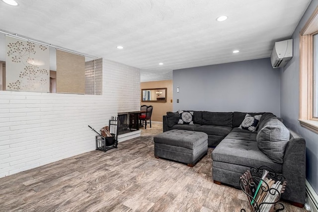 living area with an AC wall unit, baseboard heating, wood finished floors, and recessed lighting