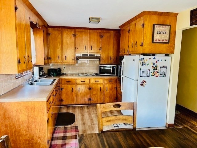 kitchen featuring sink, decorative backsplash, white fridge, and dark hardwood / wood-style floors