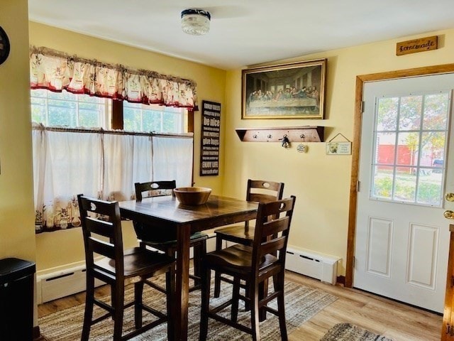 dining area featuring hardwood / wood-style floors and a baseboard heating unit