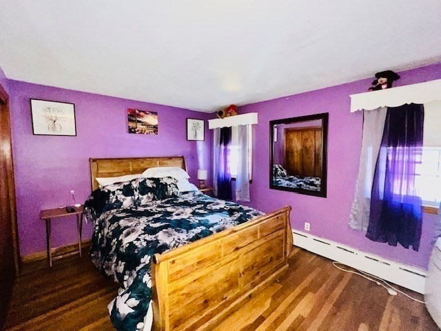 bedroom featuring dark hardwood / wood-style flooring and baseboard heating