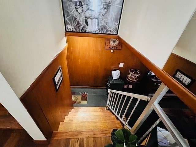 stairway featuring wooden walls