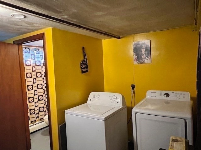 laundry area with baseboard heating and washing machine and clothes dryer