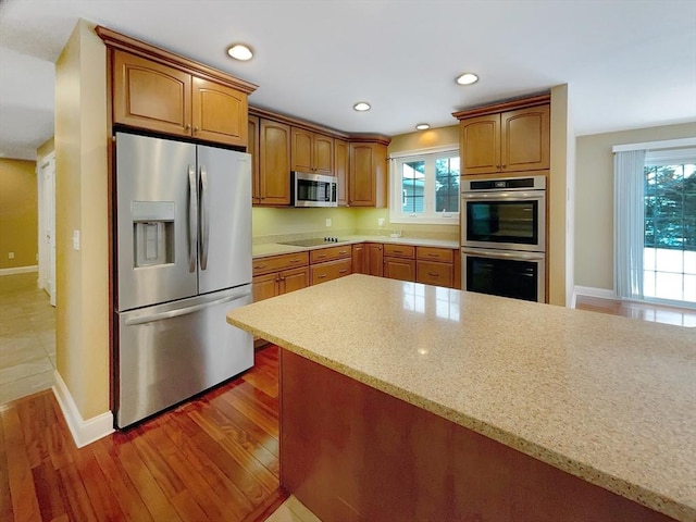 kitchen featuring light stone countertops, dark hardwood / wood-style floors, and appliances with stainless steel finishes