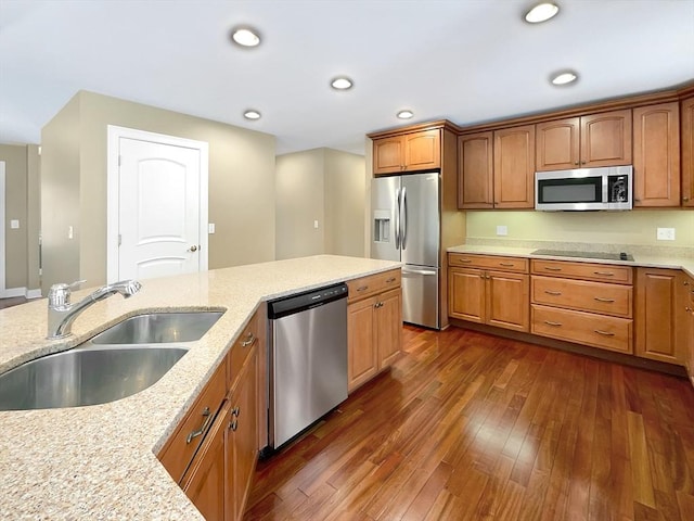 kitchen featuring light stone counters, stainless steel appliances, dark hardwood / wood-style flooring, and sink