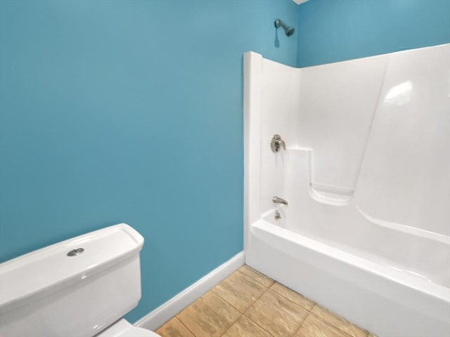 bathroom featuring shower / washtub combination, tile patterned floors, and toilet