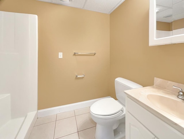 bathroom featuring tile patterned flooring, vanity, toilet, and a drop ceiling