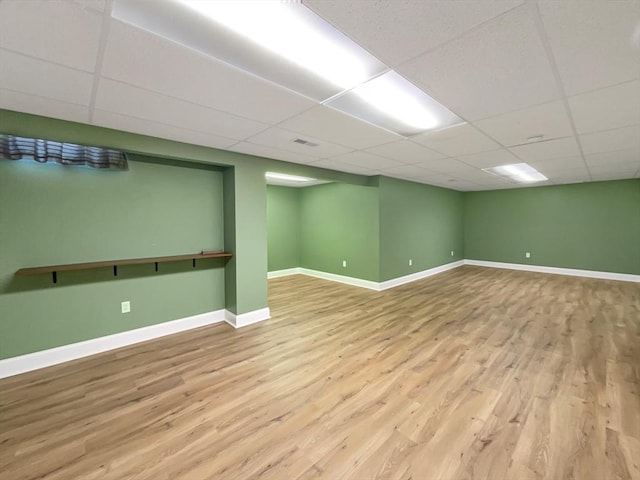 basement featuring light hardwood / wood-style flooring and a drop ceiling