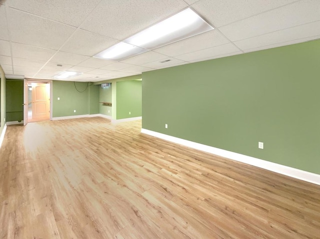 basement featuring a drop ceiling and light wood-type flooring