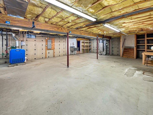 basement with sink, heating unit, and electric panel