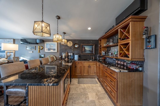 bar featuring stainless steel microwave and pendant lighting