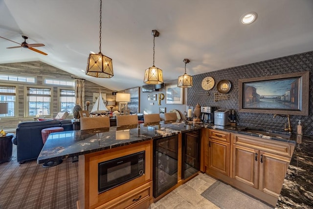 kitchen featuring decorative light fixtures, ceiling fan, sink, and black microwave