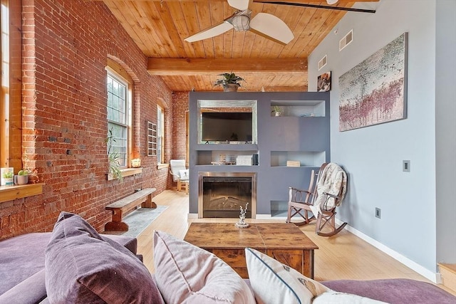 1511 Main St Unit C406, Worcester, MA 01603 - living area featuring brick wall, a wooden ceiling with exposed beams, wood finished floors, ceiling fan, and a fireplace