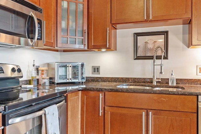 1511 Main St Unit C406, Worcester, MA 01603 - kitchen with stainless steel appliances, brown cabinets, glass insert cabinets, and dark stone counters