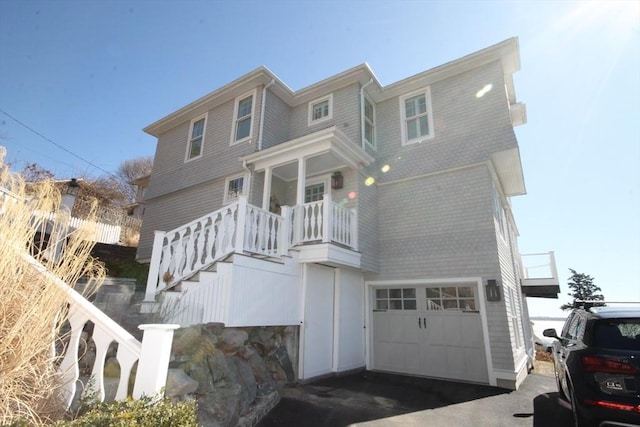 view of front facade featuring stairway, an attached garage, and driveway