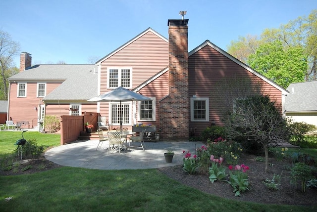15 Edmonds Rd Unit 15, Concord, MA 01742 - back of property with a chimney, a patio, and a lawn