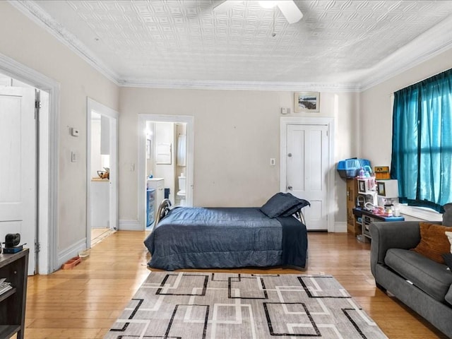 bedroom featuring ceiling fan, light hardwood / wood-style floors, connected bathroom, and ornamental molding