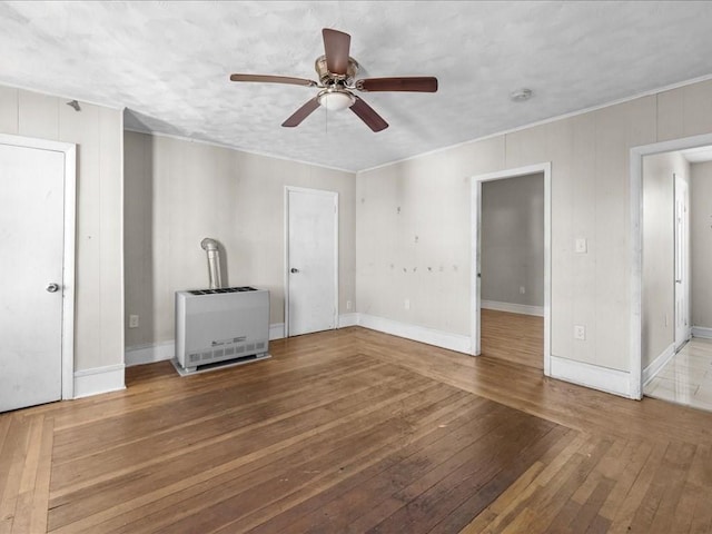 interior space featuring heating unit, ceiling fan, and hardwood / wood-style flooring