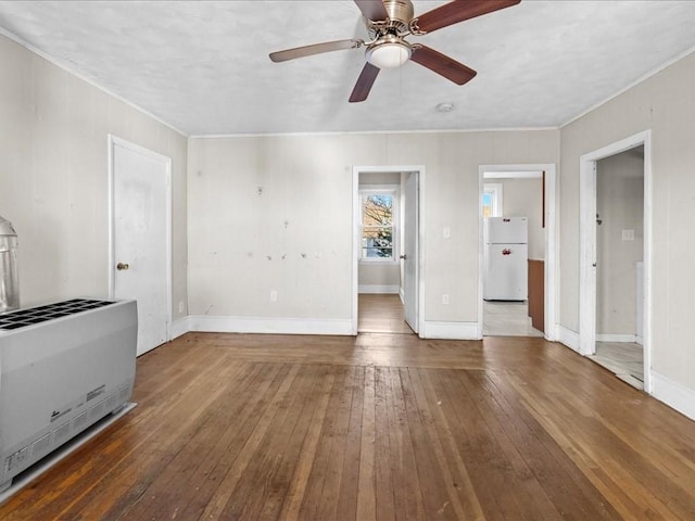 unfurnished living room with wood-type flooring, heating unit, and ceiling fan