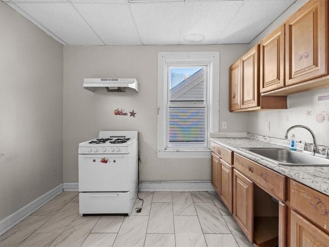 kitchen featuring light stone countertops, sink, a paneled ceiling, and white gas range oven