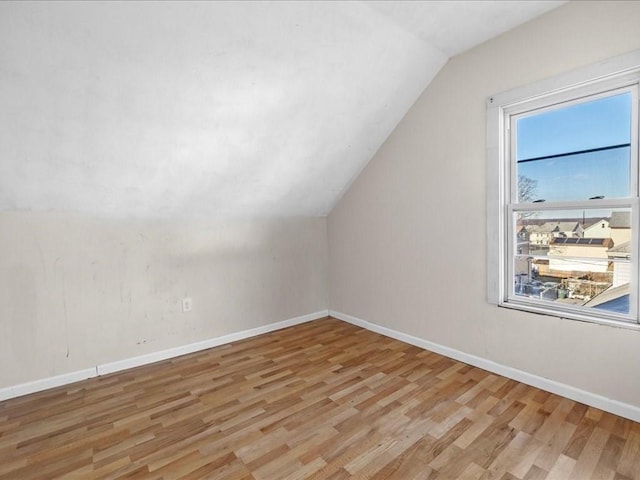 bonus room with light wood-type flooring and lofted ceiling