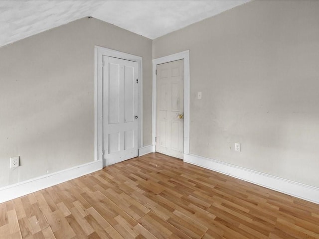 bonus room with wood-type flooring and vaulted ceiling