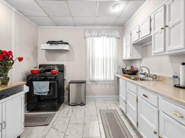 kitchen with sink, white cabinets, a drop ceiling, and gas stove