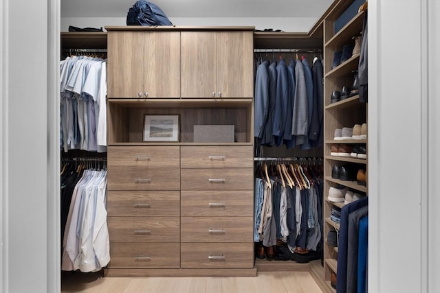 walk in closet with light wood-style floors