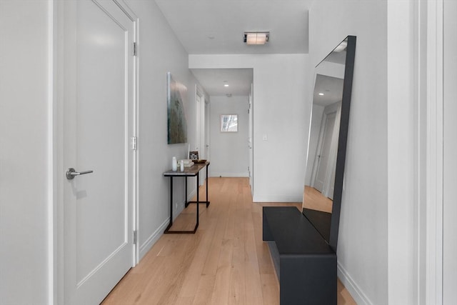 corridor with baseboards and light wood-style flooring