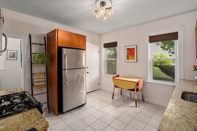574 Ashmont St Unit 1, Boston, MA 02122 - kitchen with freestanding refrigerator, brown cabinetry, black range with gas stovetop, and plenty of natural light