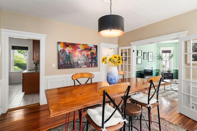 574 Ashmont St Unit 1, Boston, MA 02122 - dining space with light wood-type flooring, a wainscoted wall, a desk, and french doors