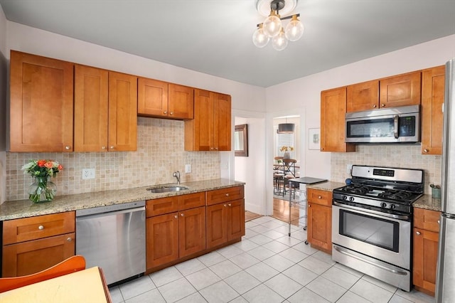 574 Ashmont St Unit 1, Boston, MA 02122 - kitchen featuring appliances with stainless steel finishes, brown cabinetry, a sink, and tasteful backsplash
