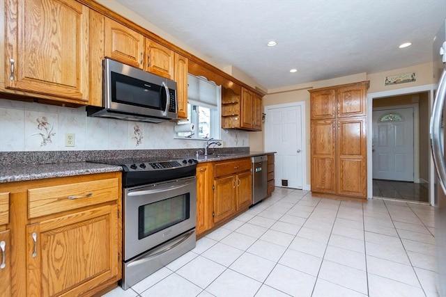 kitchen with brown cabinetry, tasteful backsplash, and stainless steel appliances