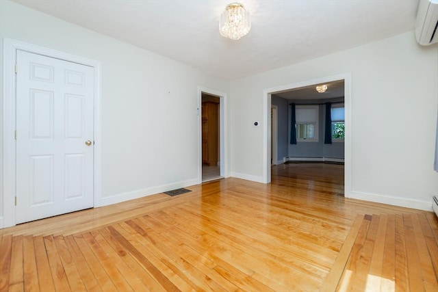 spare room featuring baseboards, a wall mounted AC, and visible vents