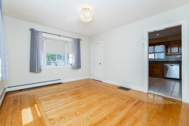spare room with visible vents, baseboards, baseboard heating, a chandelier, and hardwood / wood-style flooring
