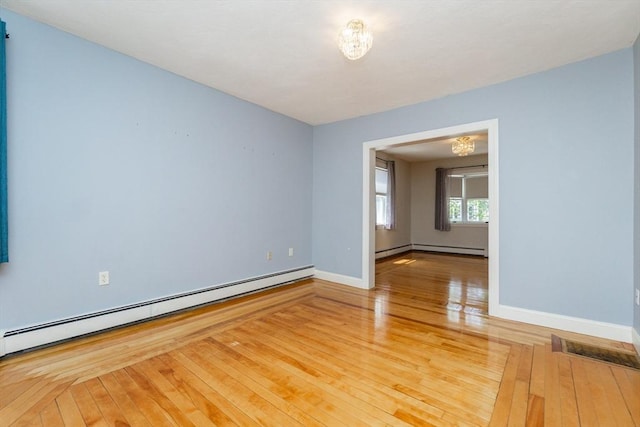 unfurnished room with wood-type flooring, baseboards, a chandelier, and a baseboard radiator