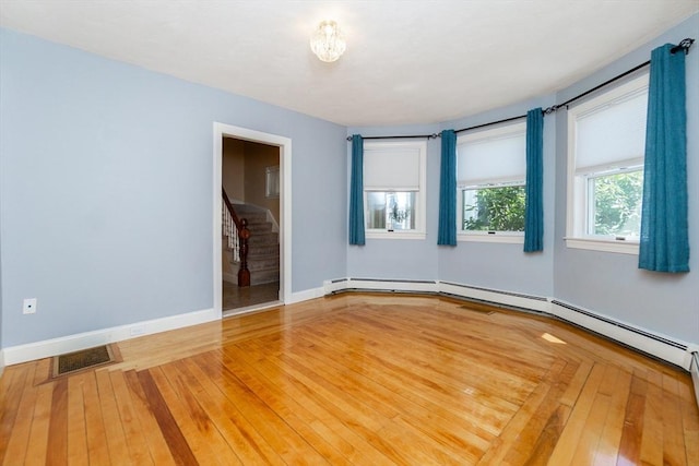empty room with stairway, baseboards, wood-type flooring, and visible vents