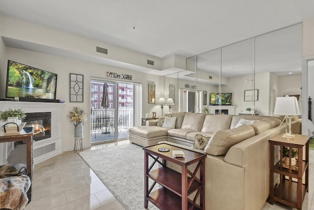 38 Village Rd Unit 309, Middleton, MA 01949 - living room featuring a glass covered fireplace, baseboards, and light tile patterned floors