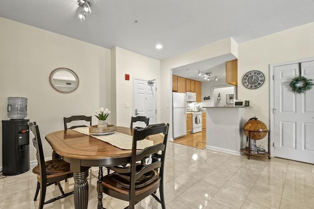 dining space featuring light tile patterned floors and rail lighting