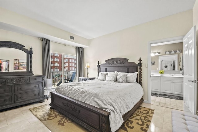 bedroom featuring light tile patterned floors, ensuite bathroom, and sink