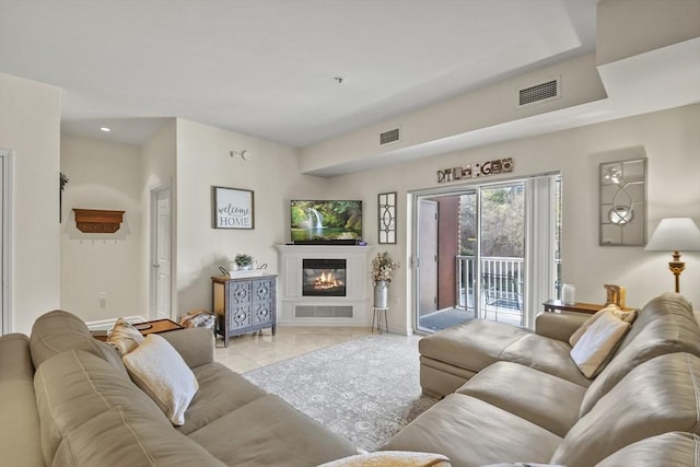 38 Village Rd Unit 309, Middleton, MA 01949 - living area featuring a glass covered fireplace, baseboards, and light tile patterned floors